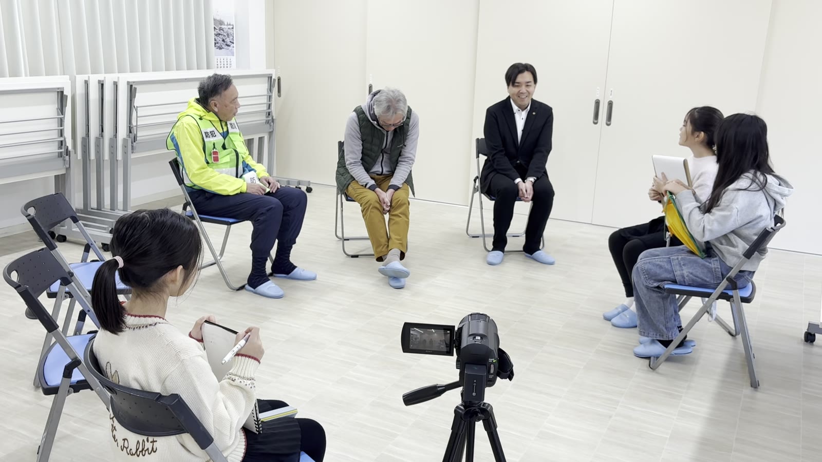 地域の大人と子どもたちが円になって話している様子